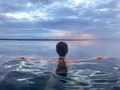 Woman from behind in an infinity hot pool looking at the ocean at sunset with her arms open Woman from behind in an infinity hot pool looking at the ocean at sunset with her arms open - PhotoDune Item for Sale