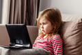 Cute todller girl sitting on couch, using tablet pad laptop gadget, watching cartoons at home Cute todller girl sitting on couch, using tablet pad laptop gadget, watching cartoons at home - PhotoDune Item for Sale