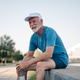 Senior man resting and smiling after working out outdoors Senior man resting and smiling after working out outdoors - PhotoDune Item for Sale