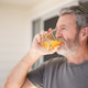 Mature handsome bearded man drinking orange juice or vitamin drink Mature handsome bearded man drinking orange juice or vitamin drink - PhotoDune Item for Sale