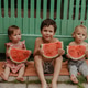 Three little children are sitting in the summer with a watermelon Three little children are sitting in the summer with a watermelon - PhotoDune Item for Sale