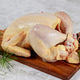 Whole uncooked chicken on wooden cutting board with pine branches and decorations ready for cooking Whole uncooked chicken on wooden cutting board with pine branches and decorations ready for cooking - PhotoDune Item for Sale