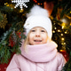 Little cute girl in winter near the Christmas tree, a place for text on the right, New Years 2022 Little cute girl in winter near the Christmas tree, a place for text on the right, New Years 2022 - PhotoDune Item for Sale