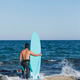 Back view of young surfer standing barefooted on sandy shore, Back view of young surfer standing barefooted on sandy shore, - PhotoDune Item for Sale
