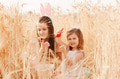 Two little girls sisters sitting in wheat field collecting red eggs in basket. Celebrating Easter Two little girls sisters sitting in wheat field collecting red eggs in basket. Celebrating Easter - PhotoDune Item for Sale