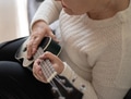 Hands of an elderly woman 70+ sitting on the sofa at home and playing the ukulele. Hands of an elderly woman 70+ sitting on the sofa at home and playing the ukulele. - PhotoDune Item for Sale