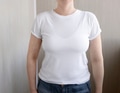 Woman wear white comfort t-shirt standing and posing above the wall. Woman wear white comfort t-shirt standing and posing above the wall. - PhotoDune Item for Sale