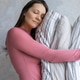 woman holds pile of pillows in her hands. pillows are in different colors, look like stack. woman holds pile of pillows in her hands. pillows are in different colors, look like stack. - PhotoDune Item for Sale