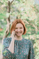 Young redhaired woman wear casual dress talk using cellphone and looking at camera. Young redhaired woman wear casual dress talk using cellphone and looking at camera. - PhotoDune Item for Sale