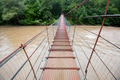 Narrow metal foot bridge across river in summer Narrow metal foot bridge across river in summer - PhotoDune Item for Sale