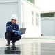 Man works on solar panels on rooftop with laptop during daytime in modern building environment Man works on solar panels on rooftop with laptop during daytime in modern building environment - PhotoDune Item for Sale