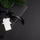 Black Christmas Gift Box with Satin Ribbon and White Blanck Label on Dark Holiday Background Black Christmas Gift Box with Satin Ribbon and White Blanck Label on Dark Holiday Background - PhotoDune Item for Sale
