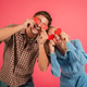 Playful couple having fun together while holding red heart shapes in a joyful and loving manner Playful couple having fun together while holding red heart shapes in a joyful and loving manner - PhotoDune Item for Sale