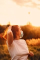 Redhead young woman wearing face mask enjoy warm sun lights at summer sunset Redhead young woman wearing face mask enjoy warm sun lights at summer sunset - PhotoDune Item for Sale