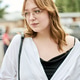 Young woman with glasses posing outdoors in casual white shirt and black top Young woman with glasses posing outdoors in casual white shirt and black top - PhotoDune Item for Sale