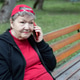 Happy elderly woman sits on bench and smilingly talks on smartphone on background of green park Happy elderly woman sits on bench and smilingly talks on smartphone on background of green park - PhotoDune Item for Sale