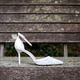 Single bridal shoe seen in profile and placed on ruined wood outdoors Single bridal shoe seen in profile and placed on ruined wood outdoors - PhotoDune Item for Sale