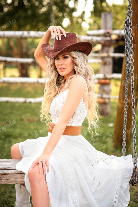 beautiful cowgirl style model posing on farmland. A beautiful girl in a white dress, a cowboy hat po Stock Photo by Vikotikk beautiful cowgirl style model posing on farmland. A beautiful girl in a white dress, a cowboy hat po Stock Photo by Vikotikk