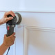 Hand using sander to smooth wood paneling in home renovation Hand using sander to smooth wood paneling in home renovation - PhotoDune Item for Sale