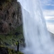 waterfall person iceland looking Seljalandsfoss waterfall person iceland looking Seljalandsfoss - PhotoDune Item for Sale