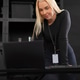 Female IT technician with laptop examining work desk in a tech office setting Female IT technician with laptop examining work desk in a tech office setting - PhotoDune Item for Sale