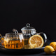 Glass teapot with amber tea, teacup with lemon slice, and bowl of honey Glass teapot with amber tea, teacup with lemon slice, and bowl of honey - PhotoDune Item for Sale
