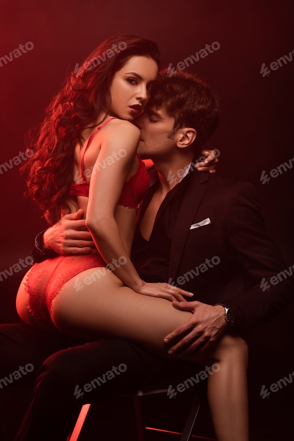 passionate boyfriend in suit hugging sexy girlfriend in red lingerie on black with red light Stock Photo by LightFieldStudios passionate boyfriend in suit hugging sexy girlfriend in red lingerie on black with red light Stock Photo by LightFieldStudios
