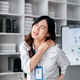 business woman is sitting at a desk with a laptop and a pain shoulder in front of her business woman is sitting at a desk with a laptop and a pain shoulder in front of her - PhotoDune Item for Sale
