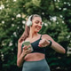 Woman checking smartwatch during outdoor workout with headphones Woman checking smartwatch during outdoor workout with headphones - PhotoDune Item for Sale