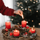 Female hand lighting all four candles on advent wreath on Christmas Eve. Female hand lighting all four candles on advent wreath on Christmas Eve. - PhotoDune Item for Sale