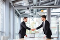Two happy businessmen standing and shaking hands on business meeting Two happy businessmen standing and shaking hands on business meeting - PhotoDune Item for Sale
