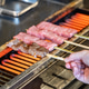 Hand barbecuing the delicious hida beef with high marbling on skewers at street market. Hand barbecuing the delicious hida beef with high marbling on skewers at street market. - PhotoDune Item for Sale