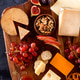 Christmas cheese platter with grapes, nuts, figs on a dark background. Christmas cheese platter with grapes, nuts, figs on a dark background. - PhotoDune Item for Sale