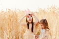 Two little girls sisters sitting in spring wheat field playing with painted eggs. Celebrating Easter Two little girls sisters sitting in spring wheat field playing with painted eggs. Celebrating Easter - PhotoDune Item for Sale