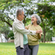 Glasses old man and woman holding hand smiling at each other while dancing together on grass in park Glasses old man and woman holding hand smiling at each other while dancing together on grass in park - PhotoDune Item for Sale