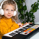 Little girl in headphones, playing the synthesizer, online piano training Little girl in headphones, playing the synthesizer, online piano training - PhotoDune Item for Sale