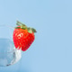 A glass glass with water and red ripe strawberries isolated on a blue background A glass glass with water and red ripe strawberries isolated on a blue background - PhotoDune Item for Sale