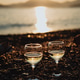 Two glasses with white wine on the beach at sunset Two glasses with white wine on the beach at sunset - PhotoDune Item for Sale