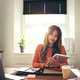 Confident young woman using a tablet in her home office Confident young woman using a tablet in her home office - PhotoDune Item for Sale