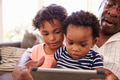 Grandfather And Grandchildren At Home Using Digital Tablet Grandfather And Grandchildren At Home Using Digital Tablet - PhotoDune Item for Sale