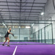 Adult Indian woman in tanktop swinging padel racket, hitting yellow ball on purple turf, copy space Adult Indian woman in tanktop swinging padel racket, hitting yellow ball on purple turf, copy space - PhotoDune Item for Sale