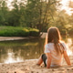 Little girl with dark hair sit on sand near forest. Female child in white t-shirt and black shorts Little girl with dark hair sit on sand near forest. Female child in white t-shirt and black shorts - PhotoDune Item for Sale