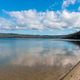 Clear waters of a tranquil lake, with mountains in the distance. Wallagoot Lake, NSW, Australia Clear waters of a tranquil lake, with mountains in the distance. Wallagoot Lake, NSW, Australia - PhotoDune Item for Sale