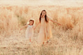 Two sisters little girls wear casual dresses having fun in wheat field. Kids in motion. Yellow color Two sisters little girls wear casual dresses having fun in wheat field. Kids in motion. Yellow color - PhotoDune Item for Sale
