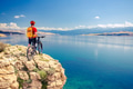 Mountain biker looking at view and riding a bike Mountain biker looking at view and riding a bike - PhotoDune Item for Sale