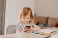 Cute toddler little girl holding smartphone, sitting at table at home, kids using technology Cute toddler little girl holding smartphone, sitting at table at home, kids using technology - PhotoDune Item for Sale