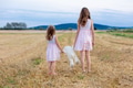 Sisters with teddy bear at autumn wheat field. Sisters with teddy bear at autumn wheat field. - PhotoDune Item for Sale
