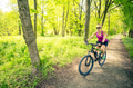 Woman cycling a mountain bike in city park, summer day Woman cycling a mountain bike in city park, summer day - PhotoDune Item for Sale