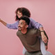 Curly girl jumped on her boyfriends back and showing peace sign. Dark-skinned couple has fun and sm Curly girl jumped on her boyfriends back and showing peace sign. Dark-skinned couple has fun and sm - PhotoDune Item for Sale