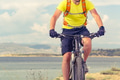 Mountain biker riding on bike at the sea Mountain biker riding on bike at the sea - PhotoDune Item for Sale